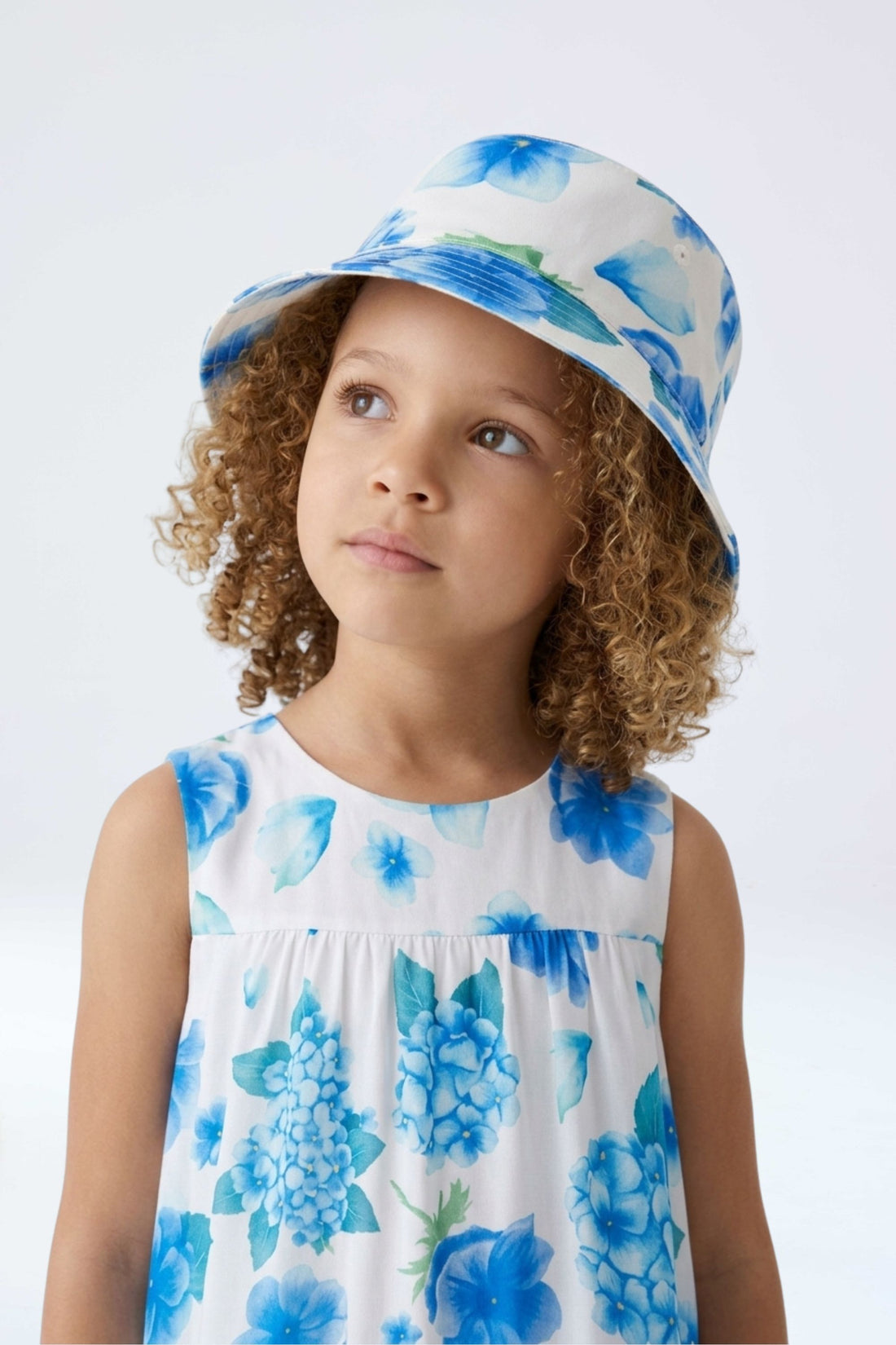 Vista con modelo Gorro reversible con estampado floral de hortensias azules de la marca Sètelle.